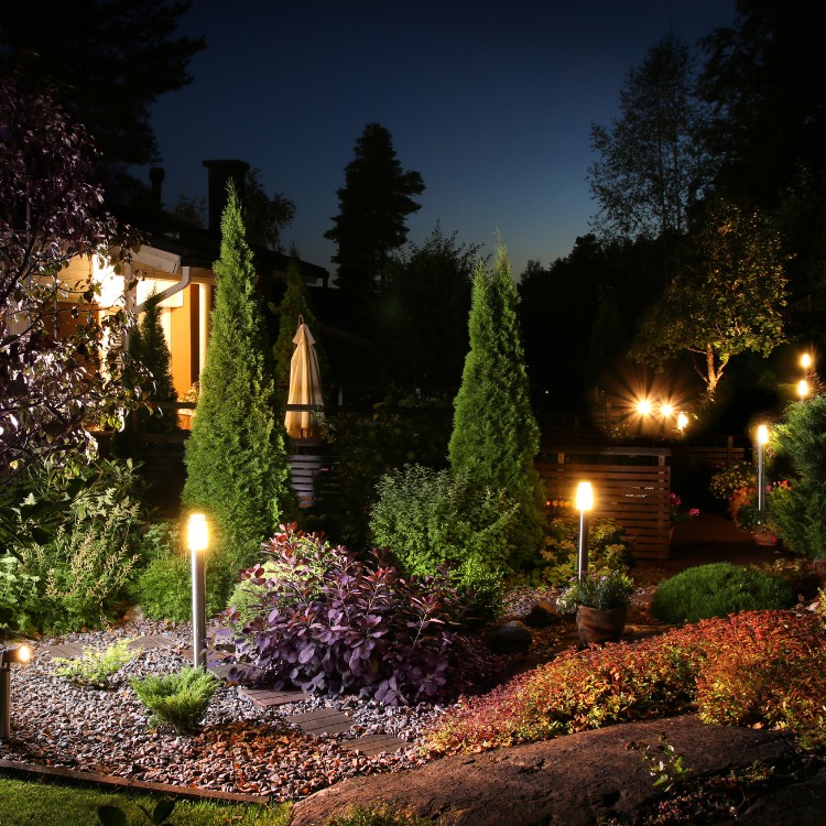 Garden path lights glowing at night in front of a home